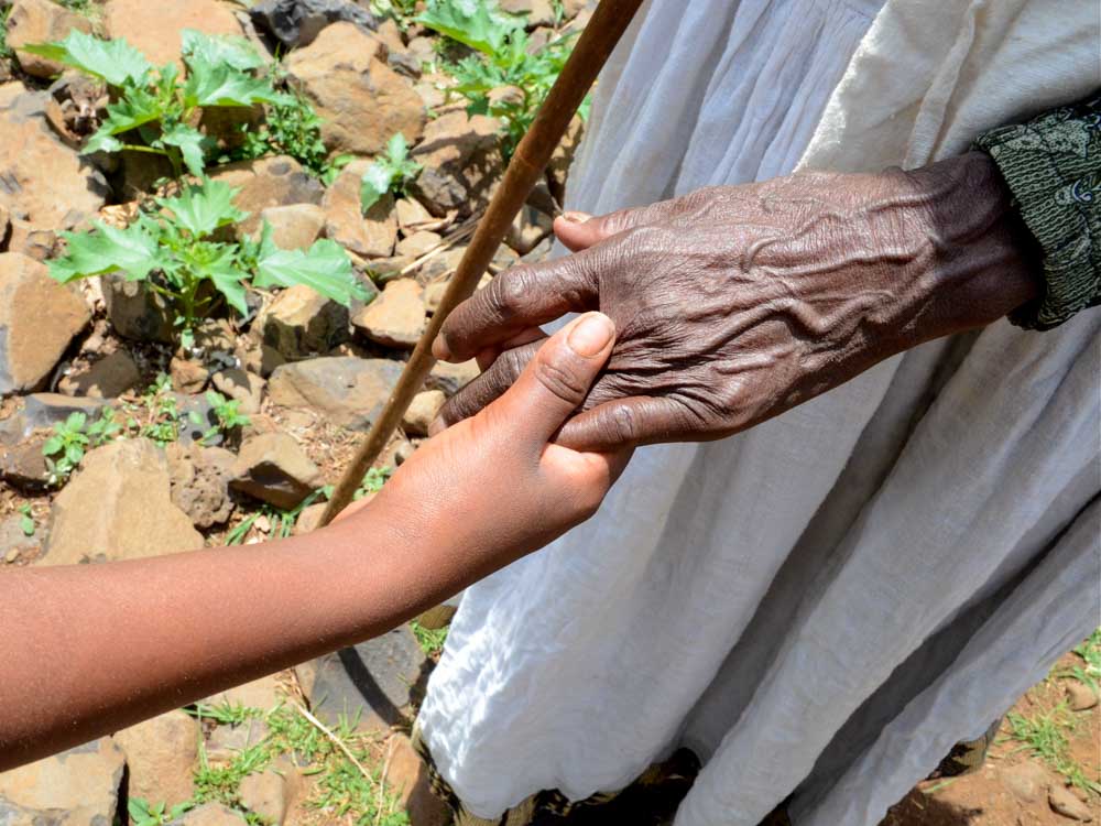 Junge und alte Hand in Äthiopien halten sich