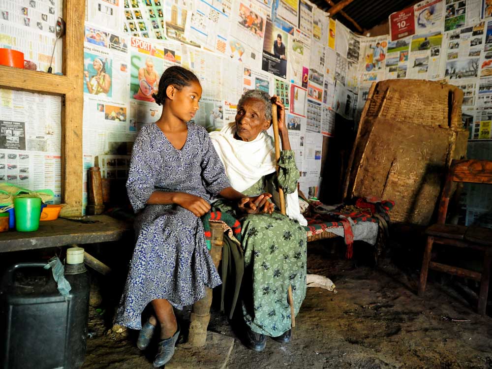Kind mit fast blinder Oma sitzen in ihrer Hütte in Äthiopien
