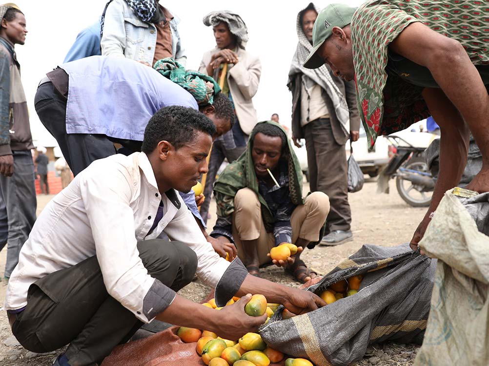Ein Mann verkauft Mangos am Markt.