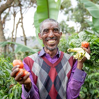 Grinsender Äthiopischer Mann mit Gemüse in der Hand