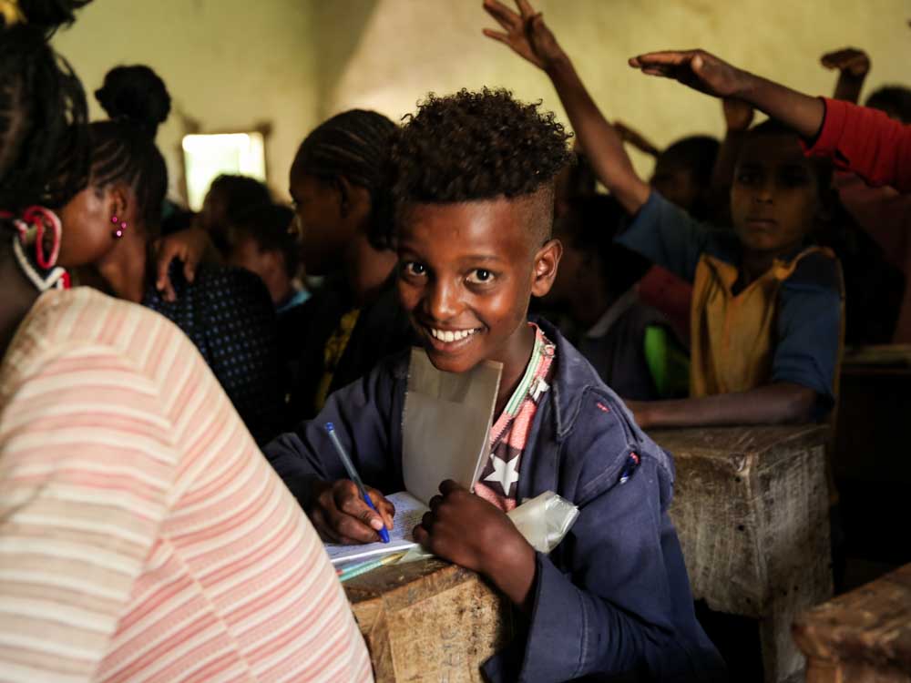 Junge in einer dunklen äthiopischen Schule lacht