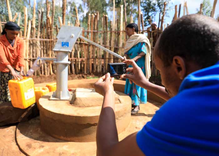 Mitarbeiter von menschen für menschen macht Foto von einem neuen Brunnen