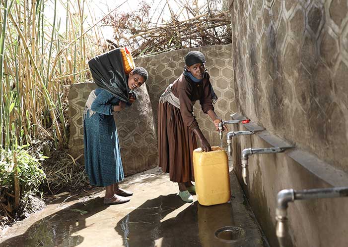 Zwei Frauen holen Wasser an neuer Quelle von mensche für Menschen in Äthiopien